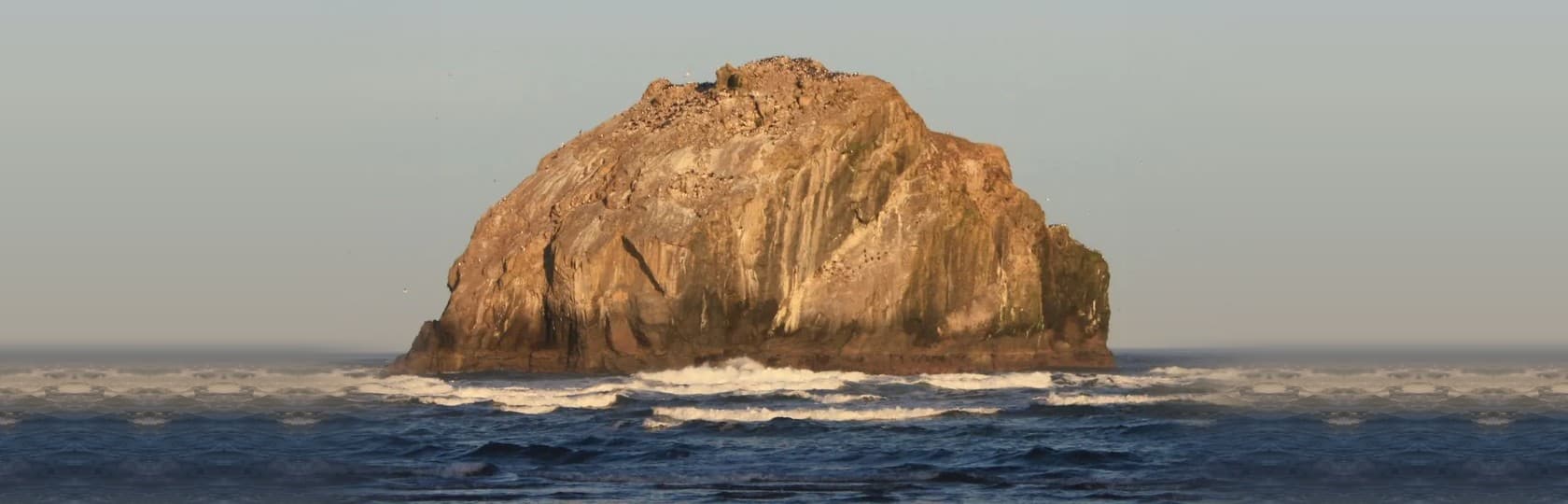 Face Rock formation at golden hour with sky and ocean